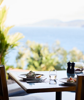 qualia Long Pavilion breakfast table with poached eggs and salad with Whitsundays views