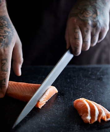 Chef hands slicing sashimi as part of Talk and Taste Sake and Sashimi experience at qualia's Long Pavilion restaurant