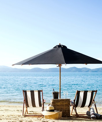 qualia Resort Luxury Beach Drop Off Experience with Two Sun Chairs and Umbrella on the Beach