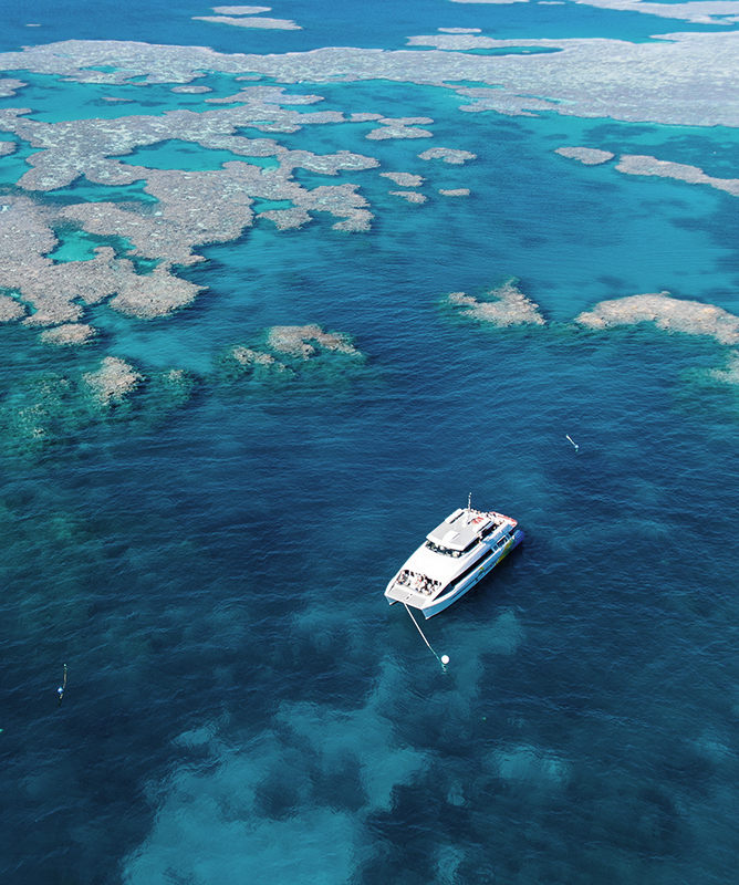 qualia resort aerial view of luxury boat amongst Great Barrier Reef for diving and snorkelling