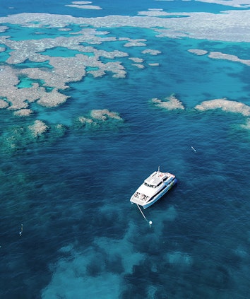 qualia resort aerial view of luxury boat amongst Great Barrier Reef for diving and snorkelling