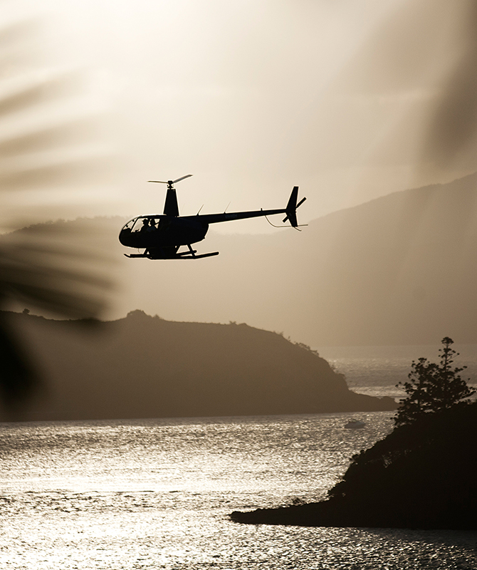 Helicopter flying low in shadow landing at qualia resort
