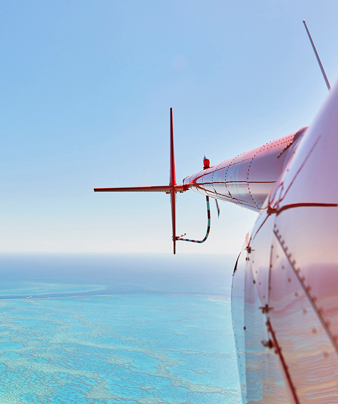 External view of pink light reflecting off side of helicopter as part of qualia scenic flight experience