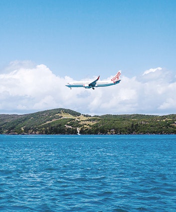 Qantas plane flying low above the water by Hamilton Island
