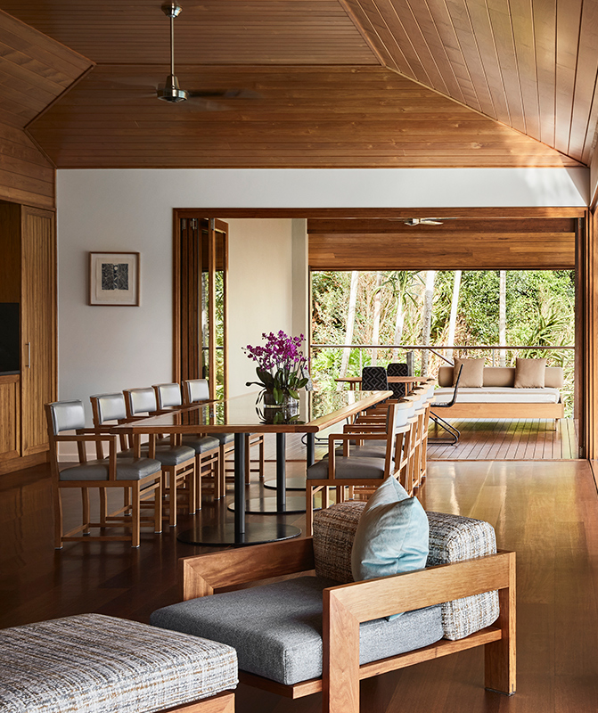 Armchair, ottoman, and dining table with ten chairs inside qualia resort's Beach House