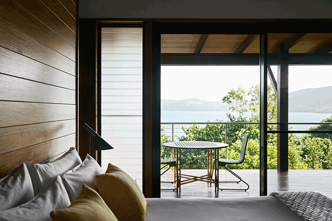 Leeward Pavilion lounge open doors towards private terrace with view of trees and the Whitsundays