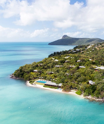 Aerial view of qualia resort including pavilions, restaurant, swimming pool and Whitsunday waters