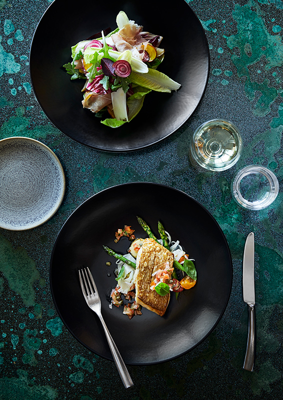 Couple sitting at Pebble Beach restaurant table for lunch with views of Whitsundays