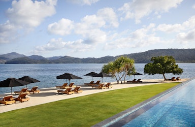 exterior view of qualia resort and surrounding trees from the calm waters of the Whitsundays 
