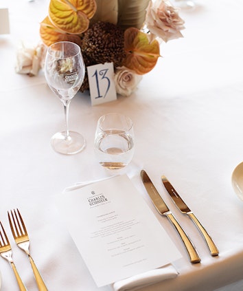 Table setting with floral arrangement, card with table number and personal menu titled 'Charles Heidsieck' for Hamilton Island Race Week at qualia resort    