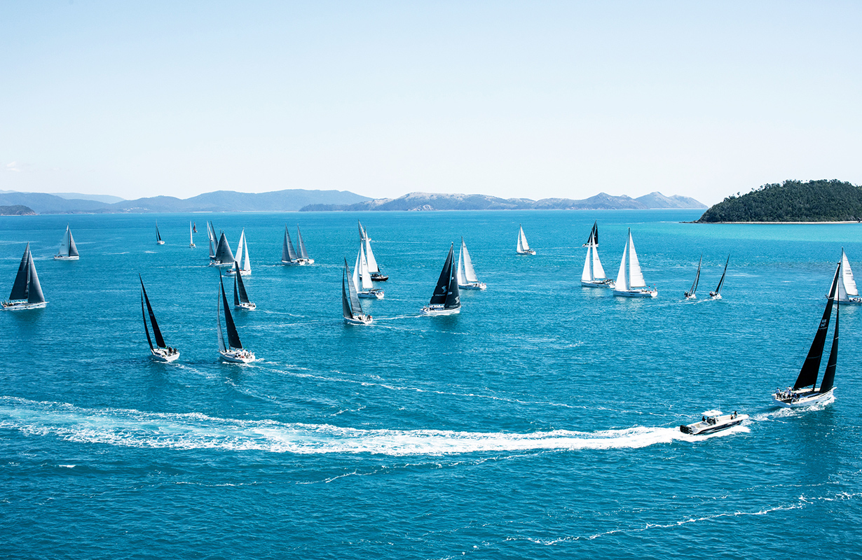 Sailing fleet passage in the turquoise waters of the Whitsundays at Hamilton Island Race Week 
