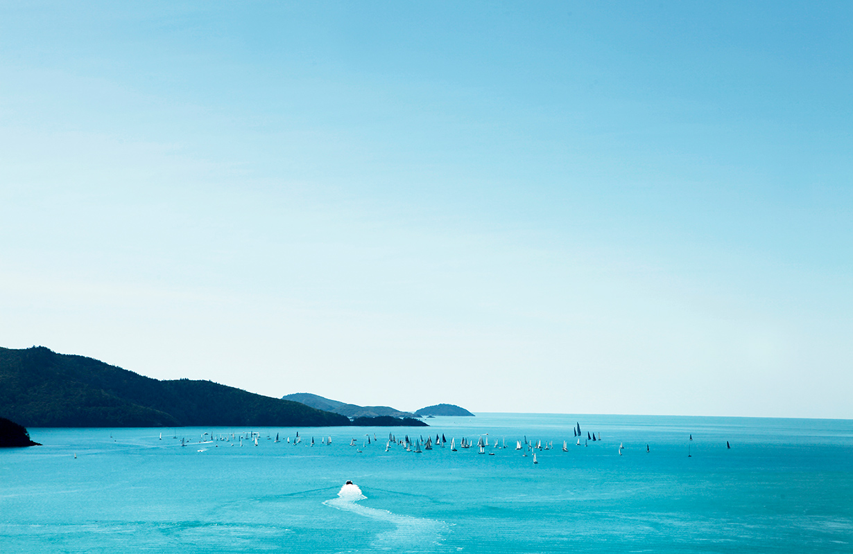 Sailing fleet passage in the turquoise waters of the Whitsundays at Hamilton Island Race Week 