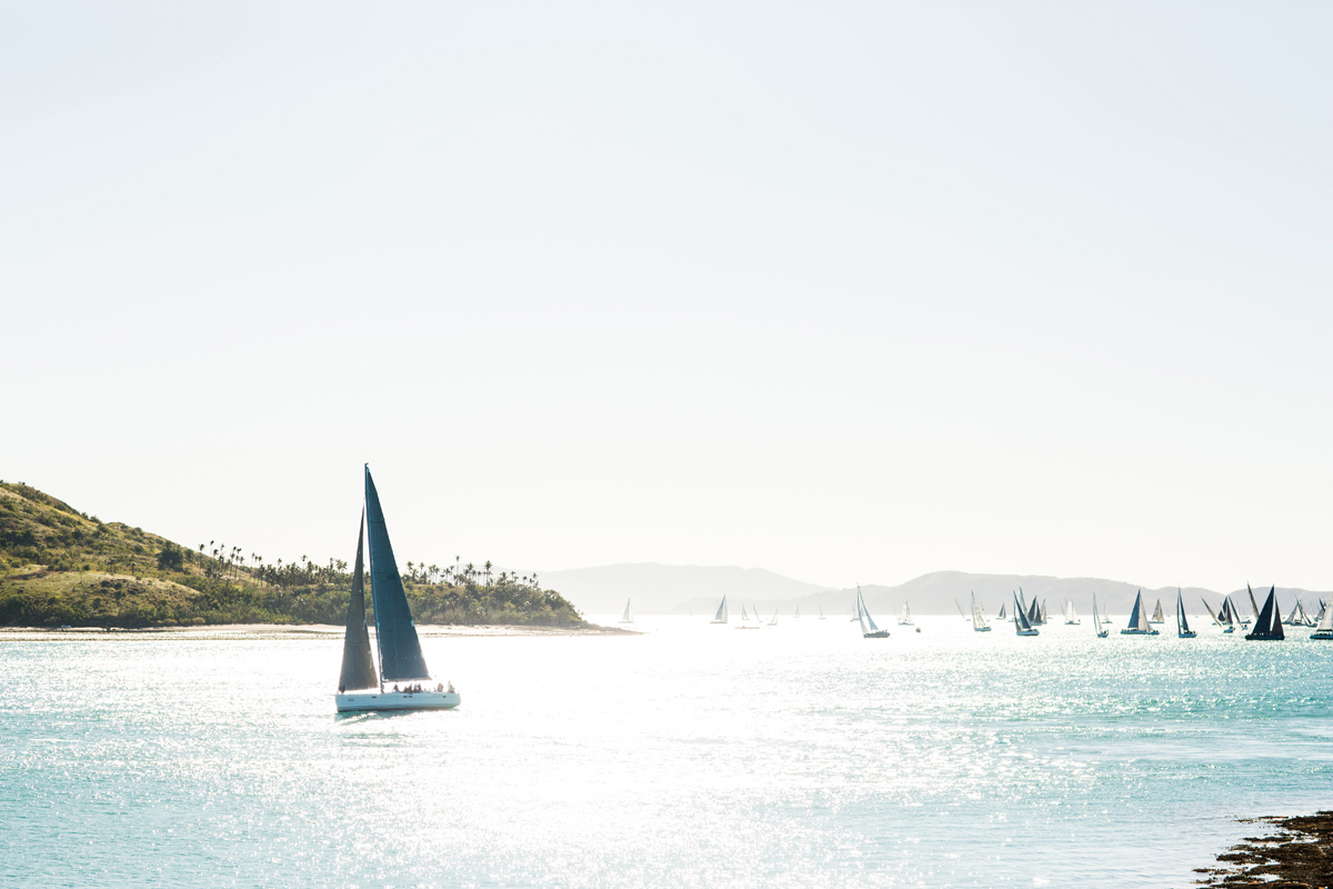 Sailing fleet passage in the turquoise waters of the Whitsundays at Hamilton Island Race Week 