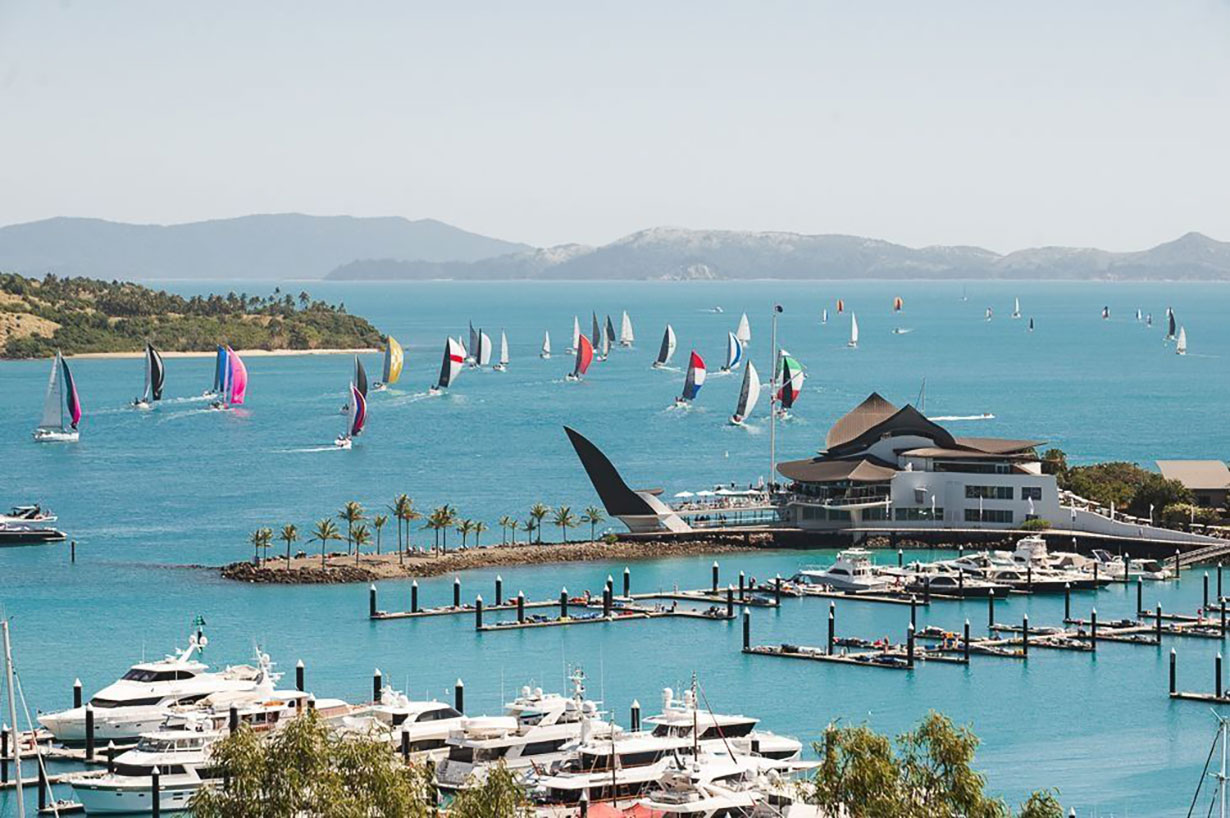 Sailing fleet passage in the turquoise waters of the Whitsundays at Hamilton Island Race Week