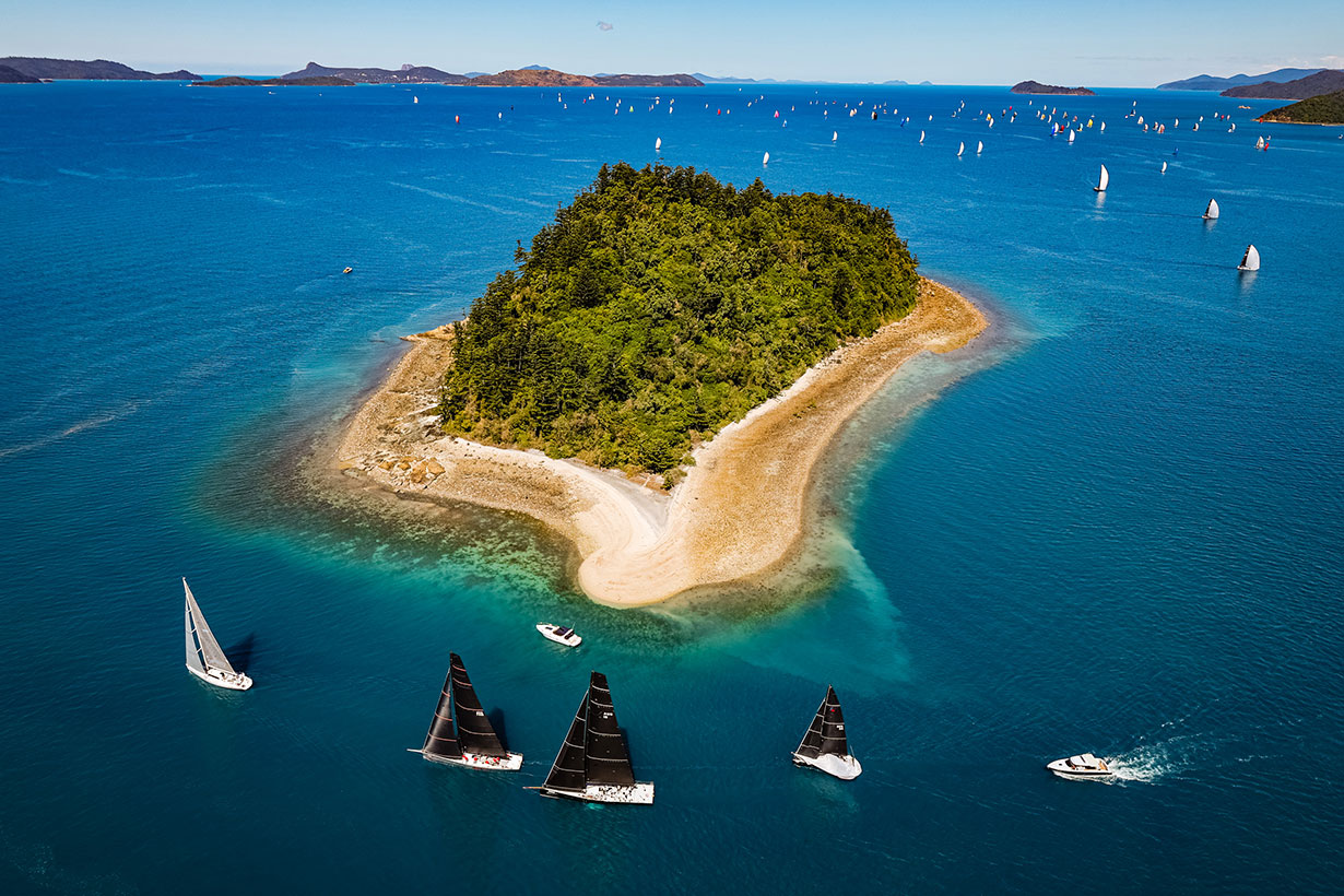 Sailing fleet passage in the turquoise waters of the Whitsundays at Hamilton Island Race Week