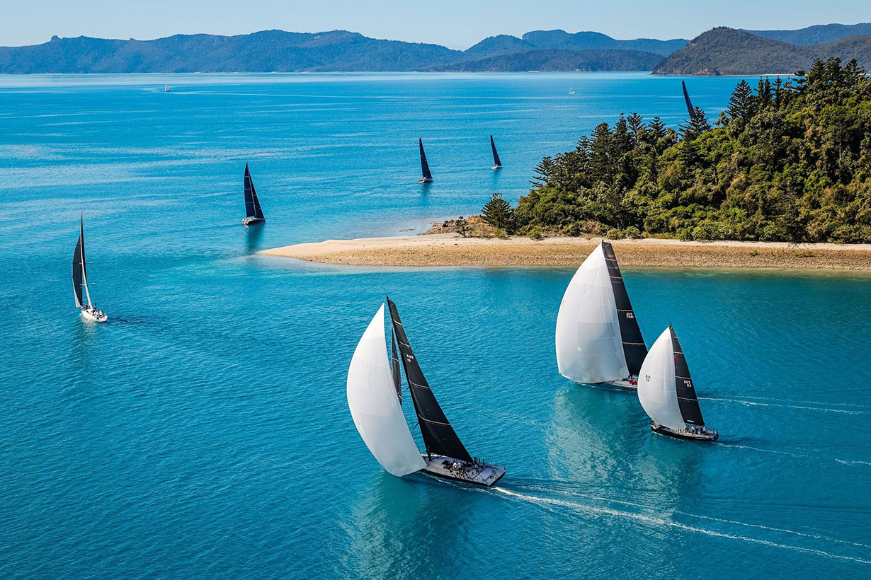 Sailing fleet passage in the turquoise waters of the Whitsundays at Hamilton Island Race Week