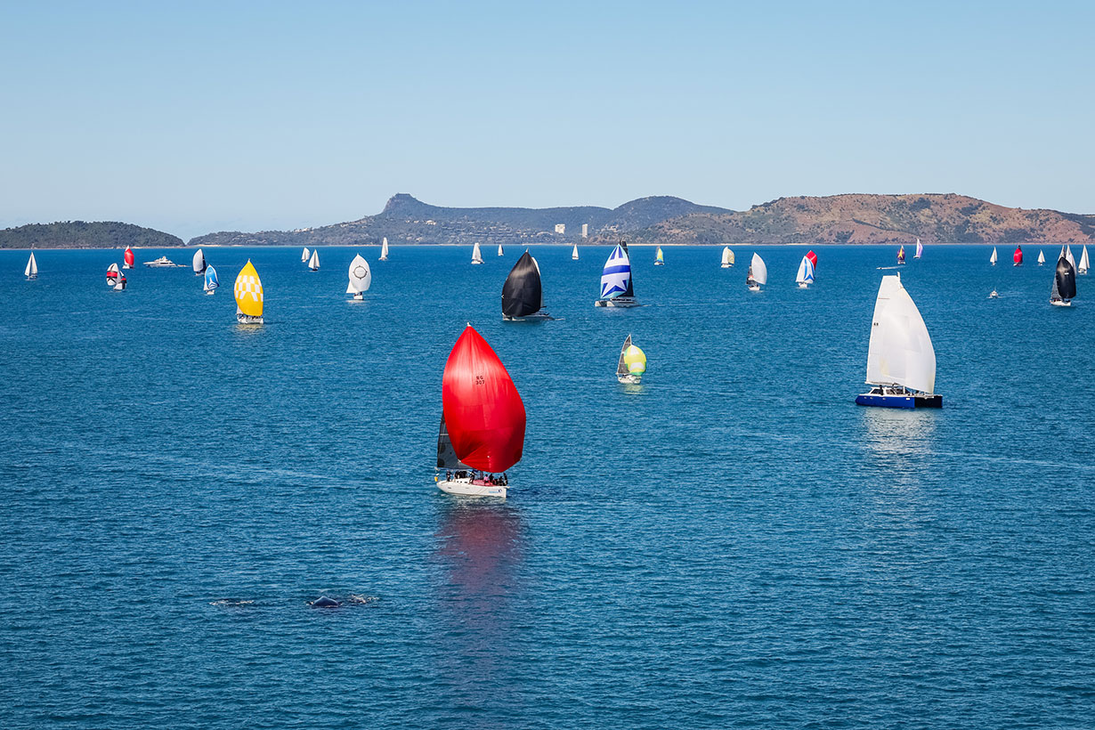 Sailing fleet passage in the turquoise waters of the Whitsundays at Hamilton Island Race Week