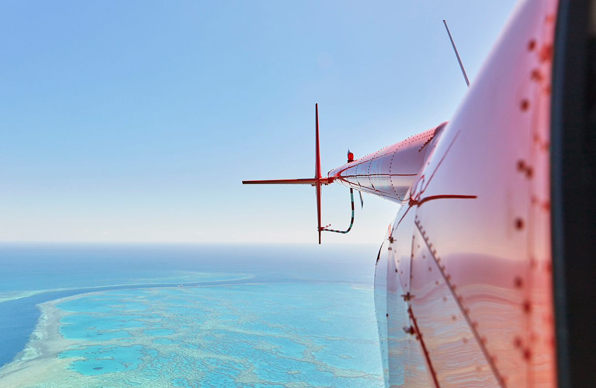 Aerial view of people enjoying waves breaking into the sand at Whitehaven Beach 