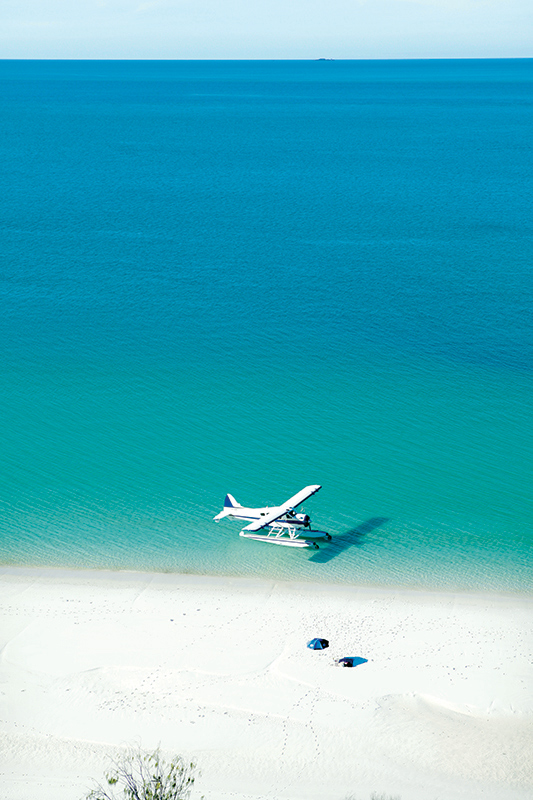 Aerial view of boat and its wake in the Whitsundays as part of qualia boating experience at Whitehaven Beach