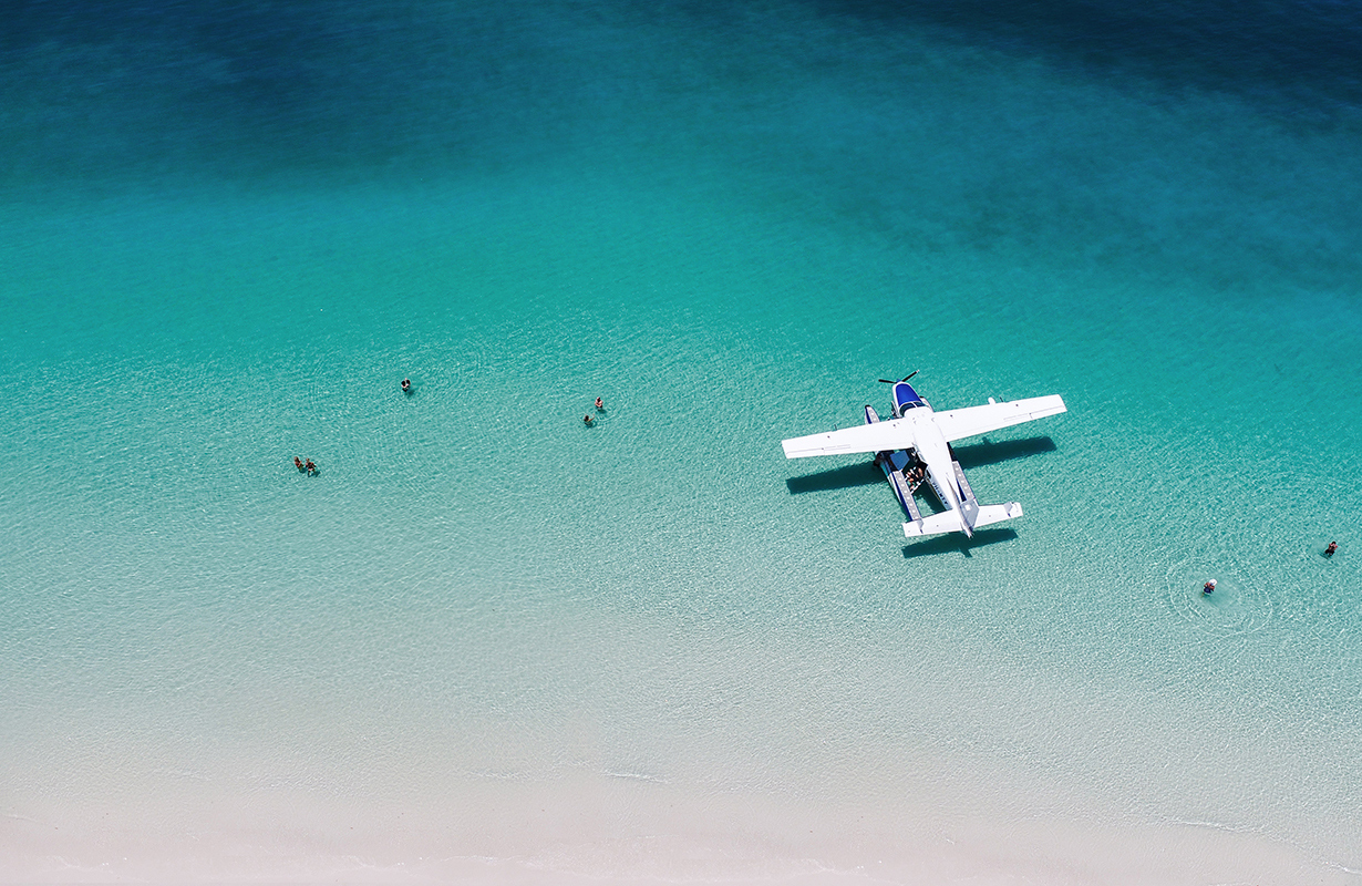 Aerial view of boat and its wake in the Whitsundays as part of qualia boating experience at Whitehaven Beach