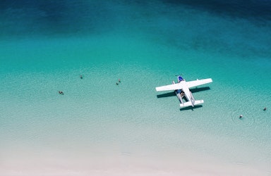 Aerial view of boat and its wake in the Whitsundays as part of qualia boating experience at Whitehaven Beach