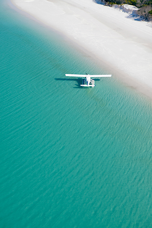 Aerial view of boat and its wake in the Whitsundays as part of qualia boating experience at Whitehaven Beach