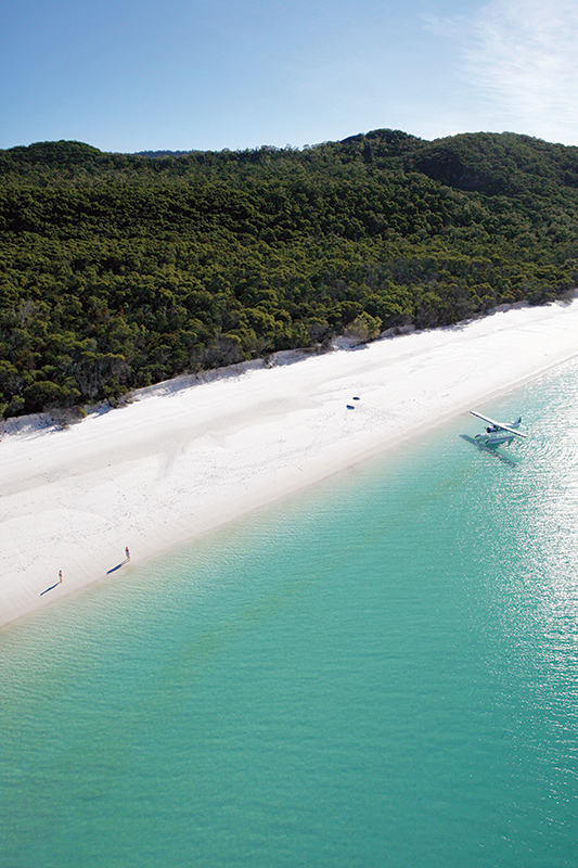 Aerial view of boat and its wake in the Whitsundays as part of qualia boating experience at Whitehaven Beach
