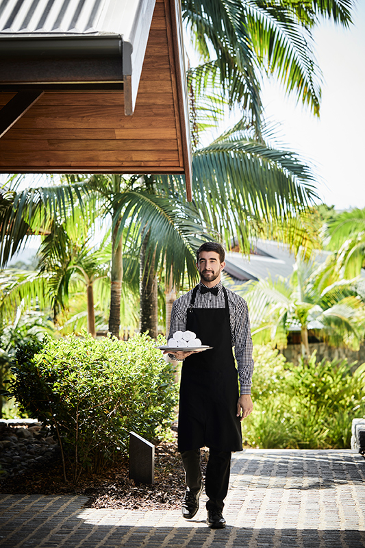 exterior view of qualia resort and surrounding trees from the calm waters of the Whitsundays 