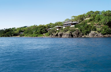 exterior view of qualia resort and surrounding trees from the calm waters of the Whitsundays 