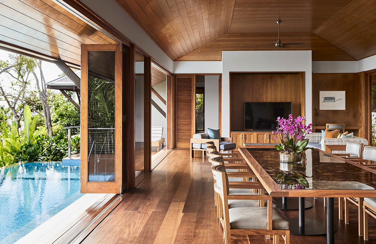 View of white bathtub and stone wall at qualia Beach House bathroom