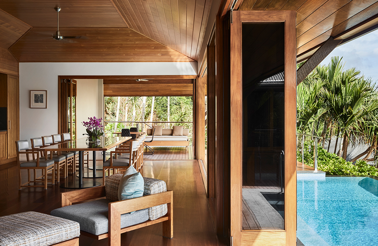 View of white bathtub and stone wall at qualia Beach House bathroom
