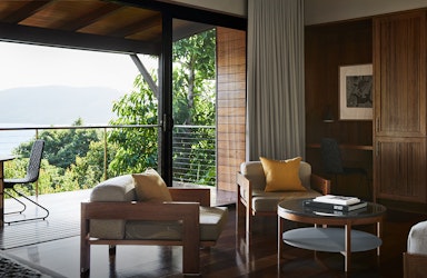 Leeward Pavilion lounge open doors towards private terrace with view of trees and the Whitsundays