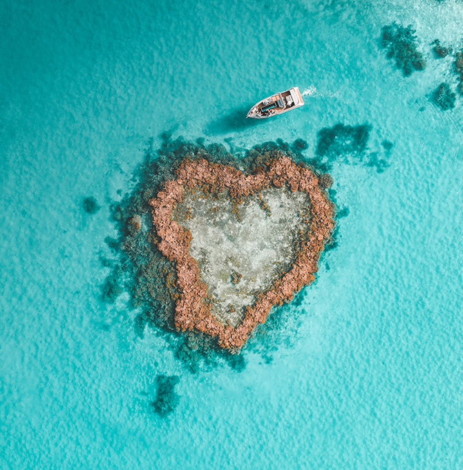 qualia resort activity of luxury Heart Island experience showing aerial of boat amongst reef