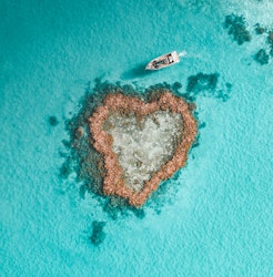 qualia resort activity of luxury Heart Island experience showing aerial of boat amongst reef