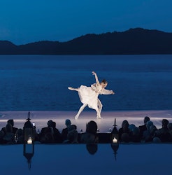 Female and male ballet dancers performing in front of an audience at qualia resort and Whitsundays in background