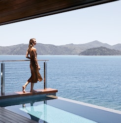 Woman standing on edge of private plunge pool of qualia Windward Pavilion looking at Whitsundays views