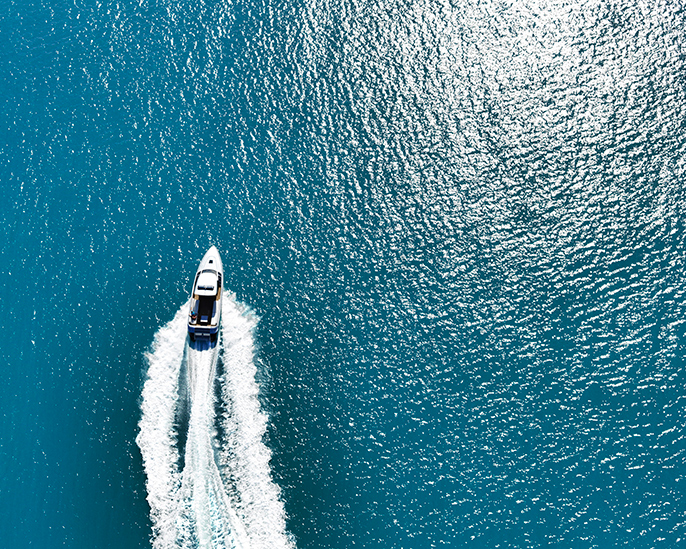 qualia resort boating experience with the wake of a boat across the bright blue Whitsundays waters 