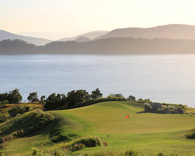 qualia view of red pin on Dent Island Golf course with sunlight pouring from the Whitsundays