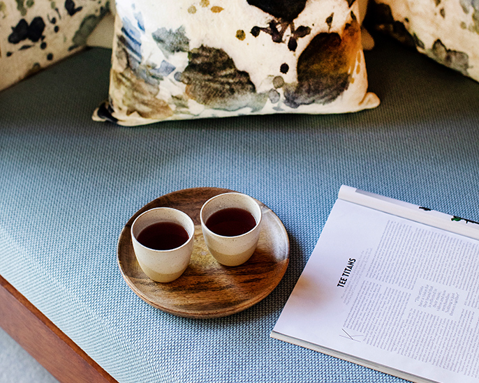 Tray with two cups of tea and a magazine with page titled tea titans at spa qualia 