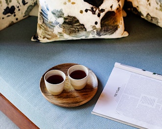 Tray with two cups of tea and a magazine with page titled tea titans at spa qualia 