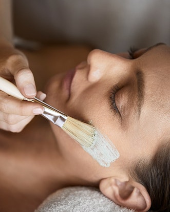 Woman receiving spa treatment facial at spa qualia
