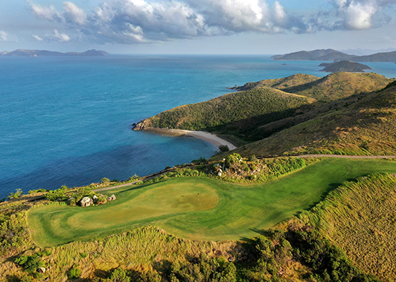 qualia aerial view of Dent Island Golf Course with rolling hills surrounded by Whitsundays