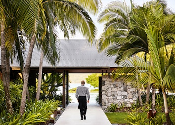 Waiter walking through garden path at qualia resort restaurant Pebble Beach