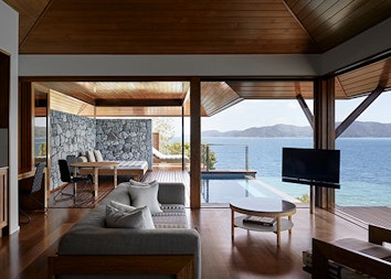View of private deck with plunge pool and the Whitsundays from inside Windward Pavilion lounge