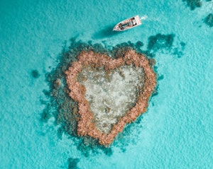qualia resort activity of luxury Heart Island experience showing aerial of boat amongst reef