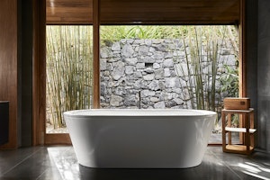 View of white bathtub and stonewall at qualia Beach House bathroom