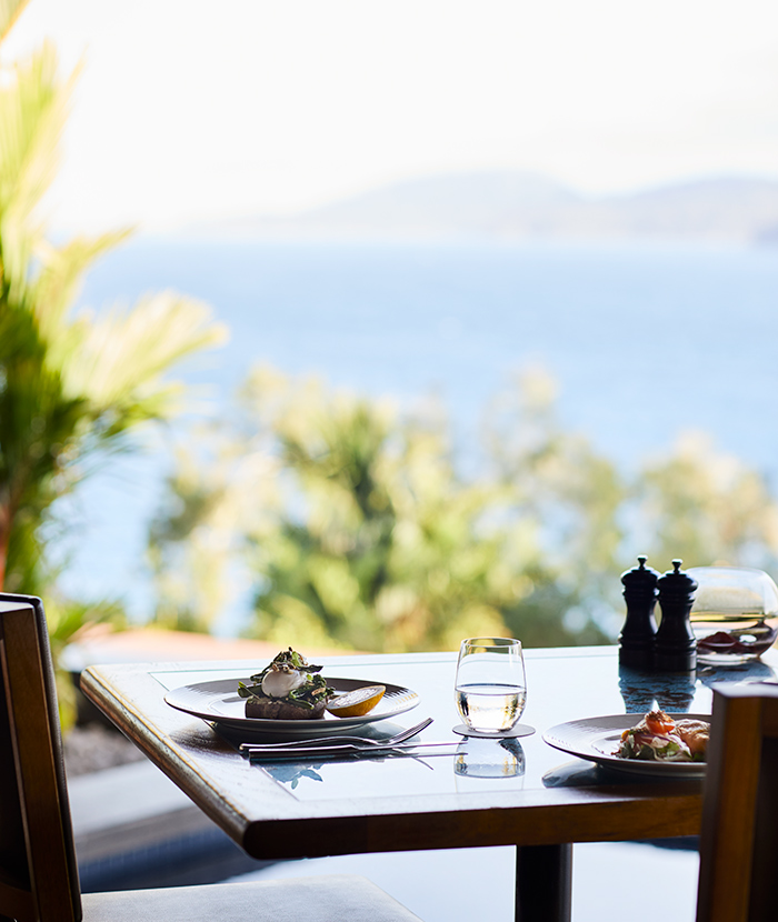 qualia Long Pavilion breakfast table with poached eggs and salad with Whitsundays views