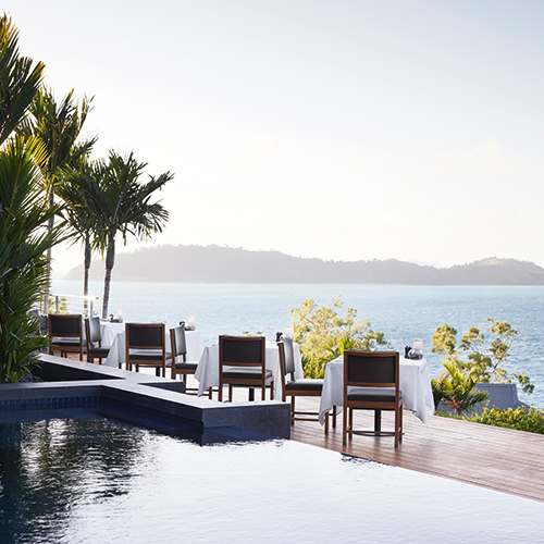 Whitsunday sunset view from dinner tables set outdoor at qualia resort's Long Pavilion restaurant