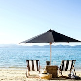 qualia resort luxury Beach Drop Off Experience with two sun chairs and umbrella on the beach