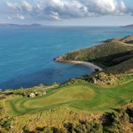 qualia aerial view of Dent Island Golf Course with rolling hills surrounded by Whitsundays